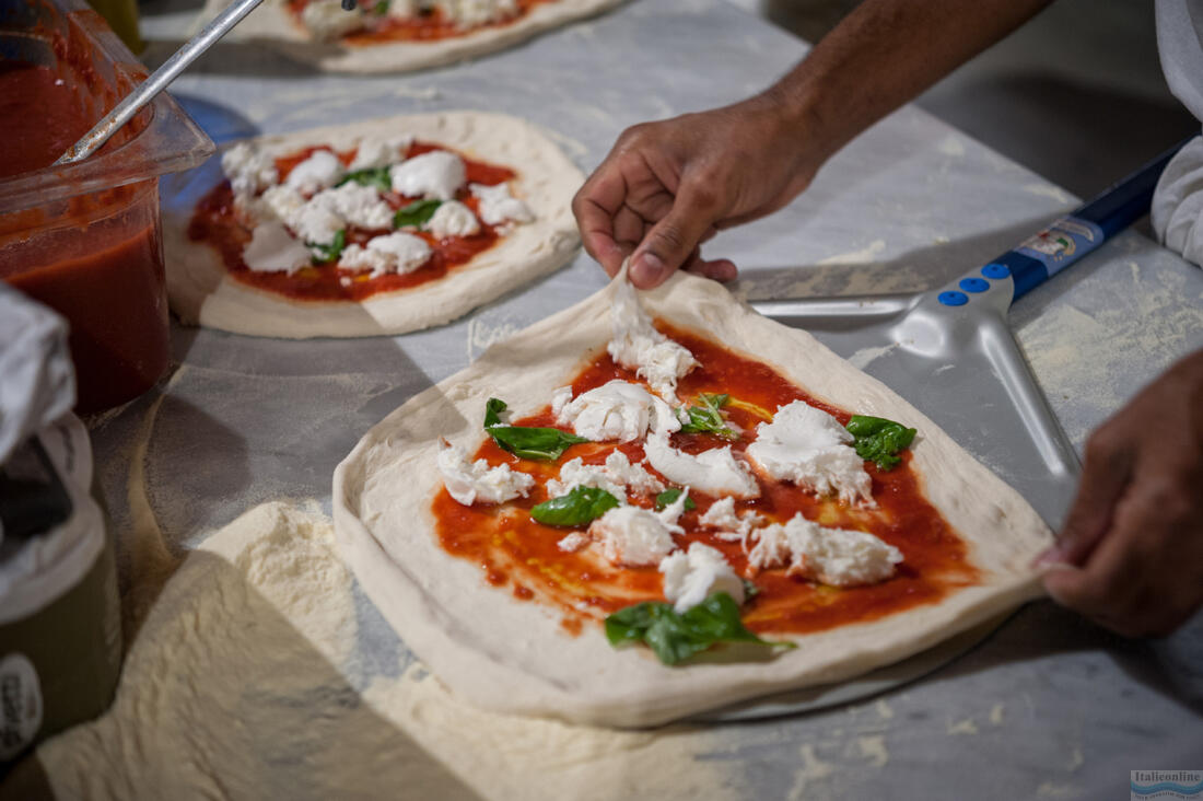 Pizzaiolo puts the pizza dough on the pizza peel
